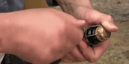 Как да отворите шампанско със собствените си ръце: Премахване на телта държи тапата с пръст